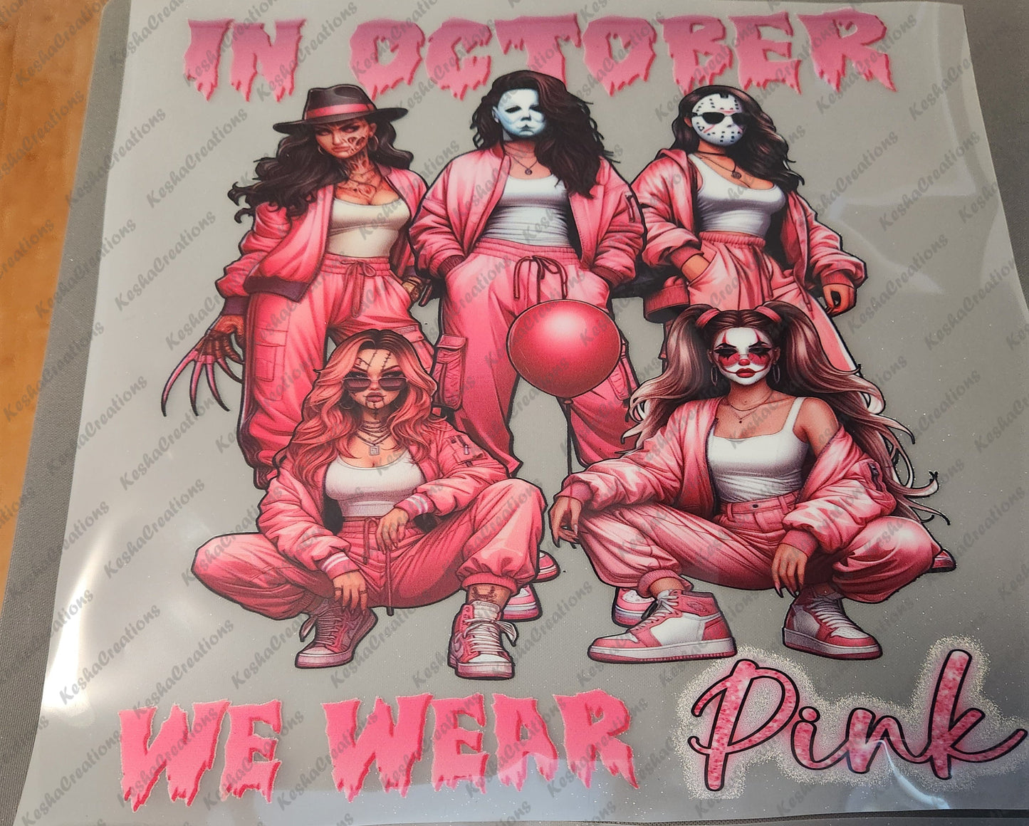 DTF transfer design featuring five women dressed in pink athletic outfits, each representing a famous horror character, with the text 'In October We Wear Pink' in a dripping pink font.