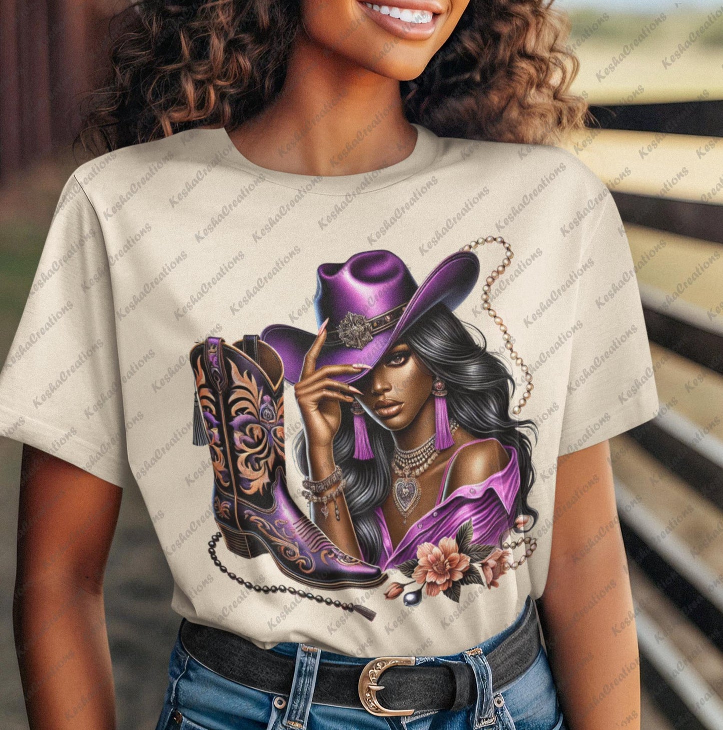 Woman smiling in a cowboy hat, modeling a T-shirt featuring a DTF transfer of a glamorous Black cowgirl in a purple outfit with ornate boots, floral accents, and beaded jewelry. Exclusive to KeshaCreations.