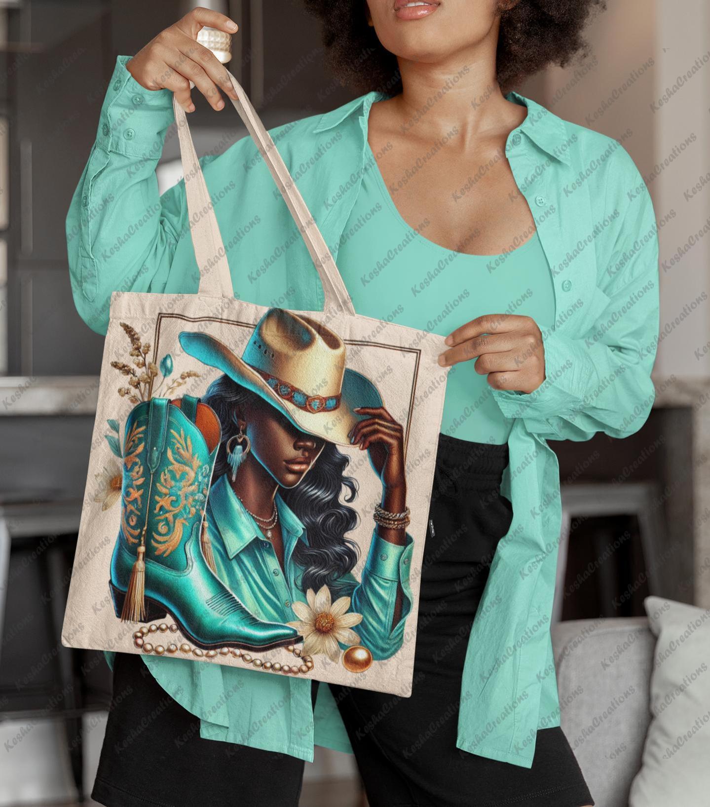 Woman indoors holding a beige tote bag printed with a DTF transfer of a stylish cowgirl in a tan hat and teal shirt, with coordinated boots, jewelry, and floral elements. A bold, Western-chic accessory by KeshaCreations.